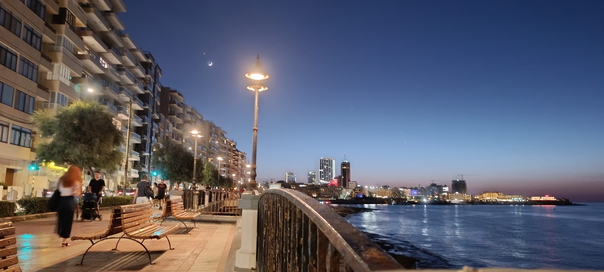 Sliema vs St Julian's - the Sliema promenade at dusk with the St Julian's skyline across the bay