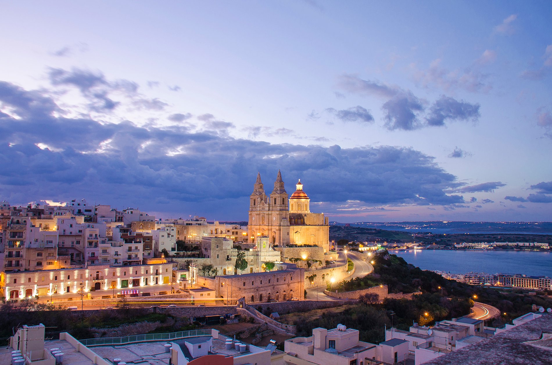 Mellieħa village and parish church lit up at dusk