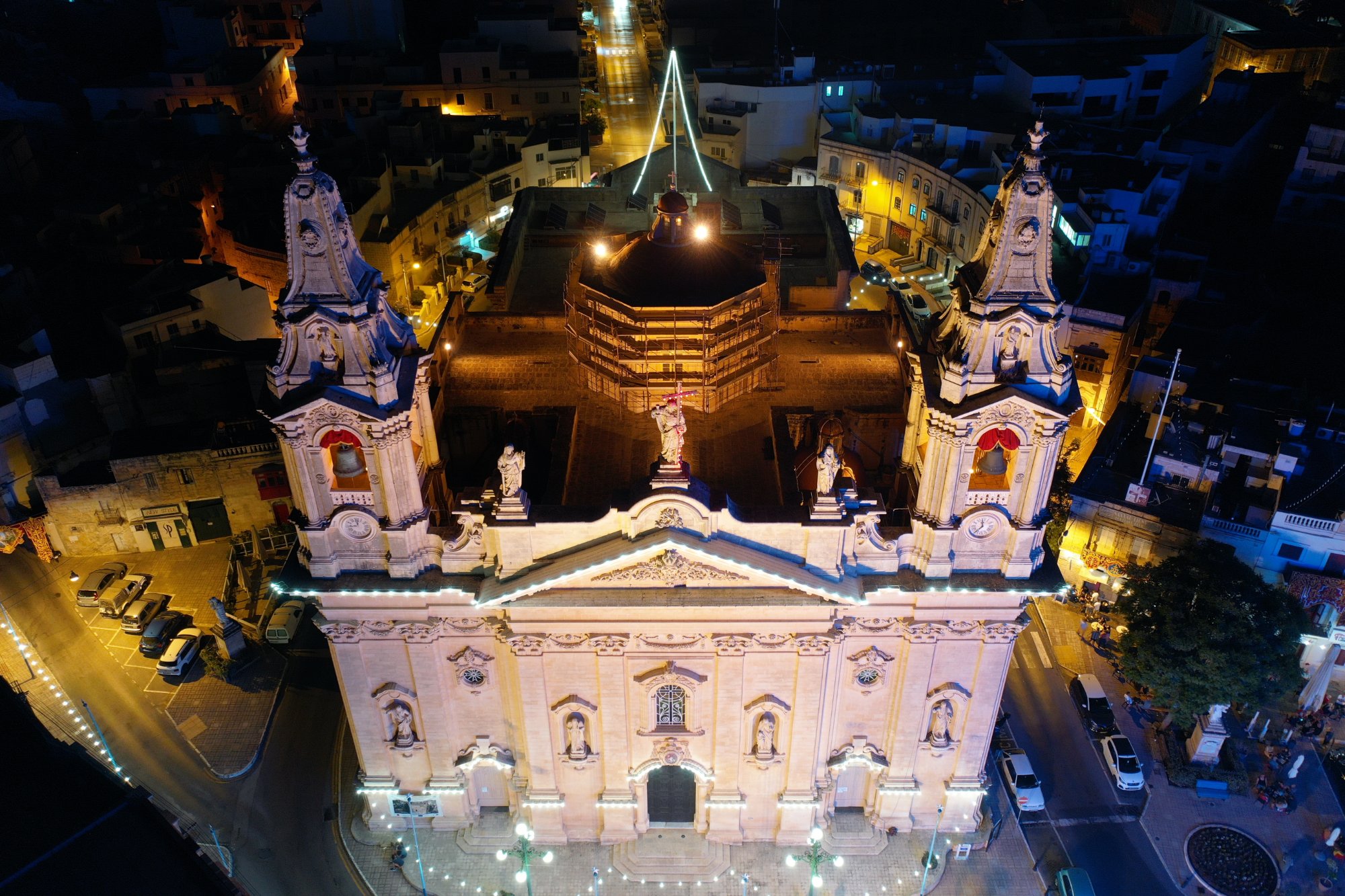 Naxxar parish church lit up at night over the village square